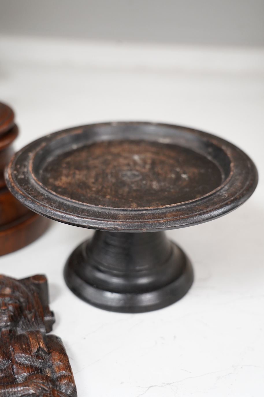 A 17th century carved oak mask corbel, another smaller, a small tazza and a carved wood pot and cover, tallest 19.5cm. Condition - fair to good